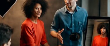 Desen digital al unui oraș futurist noaptea, cu clădiri înalte și lumini neon albastre și violete, cer înstelat și mașini zburătoare pe străzi.